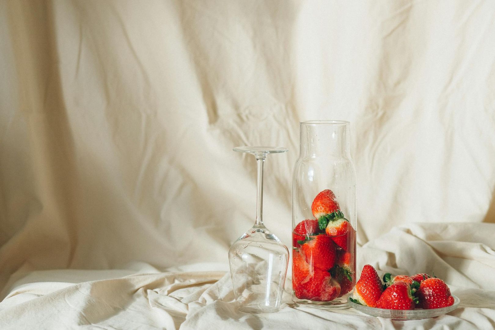 Jordgubbar i flaska och glas, med ljus bakgrund. Ingen barnmode.